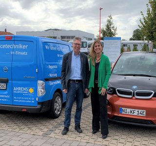 Dieter Ahrens und Katja Keul vor ihren Elektrofahrzeugen